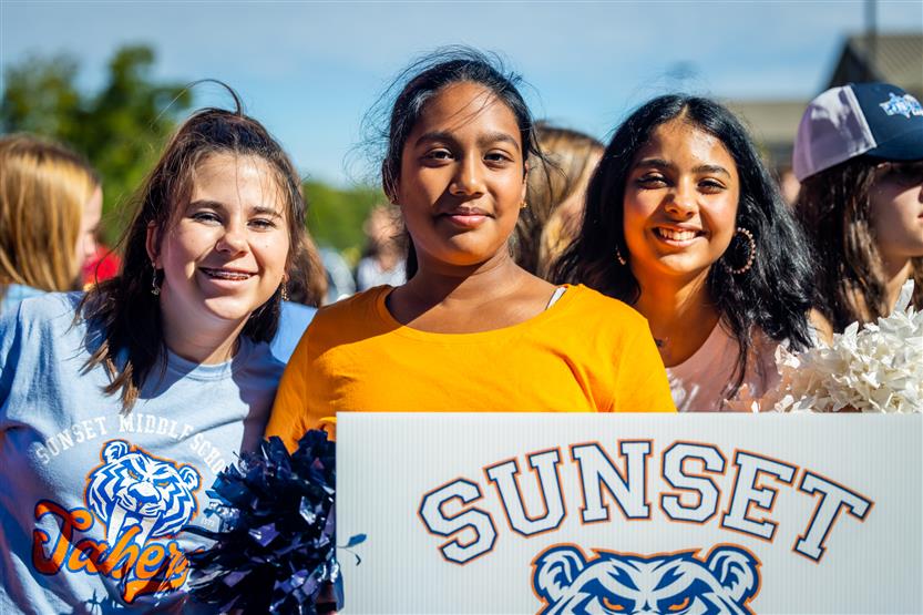 Students smile during a homecoming parade